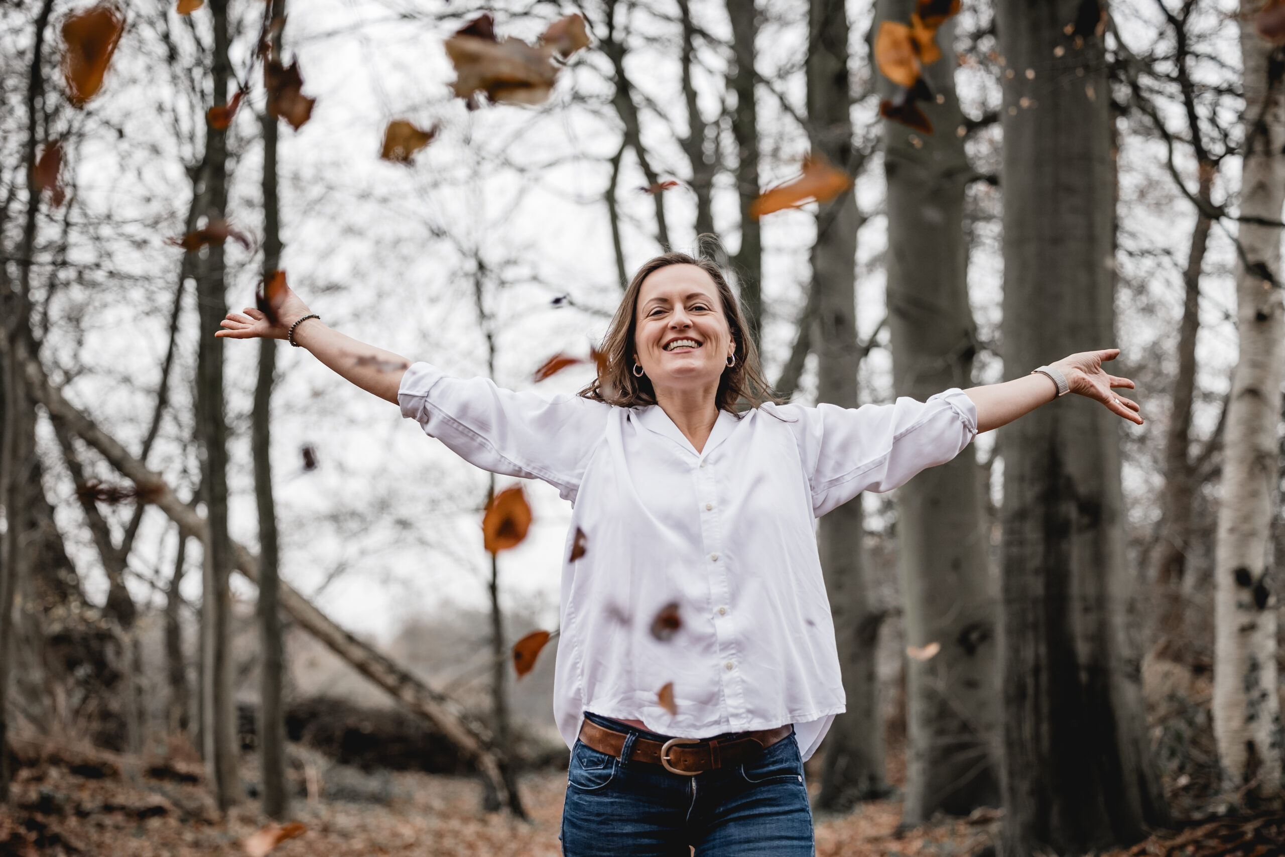 Britta Sojka im Herbstwald, die Arme ausgebreitet – Freiheit und Leichtigkeit